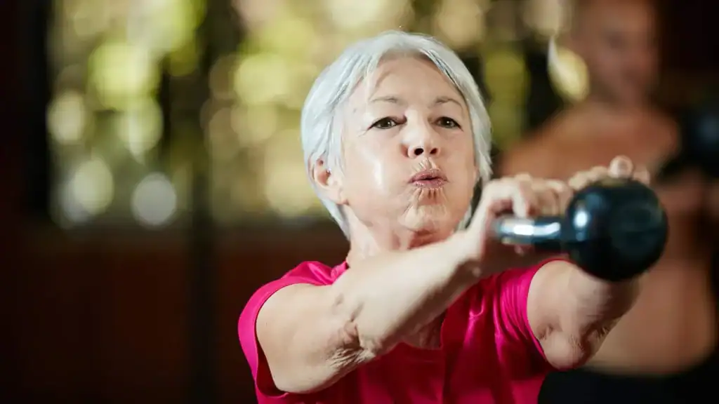 Older woman doing weight training Chesterfield to help her strength and longevity 