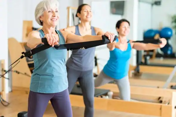 Toning Arms After 60: Empowering Womens Fitness Through Effective Weight Training 2 older woman doing weight training Chesterfield and resistance in the gym to tone upper arms