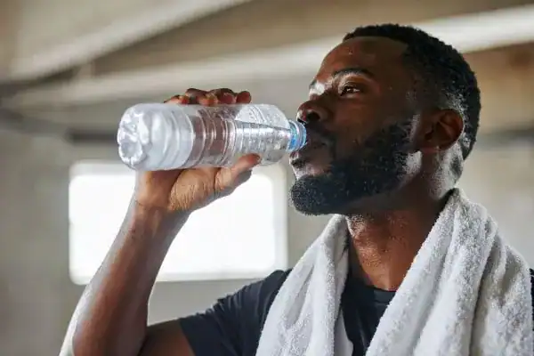 Image of man drinking water to improve hydration Chesterfield after work out.